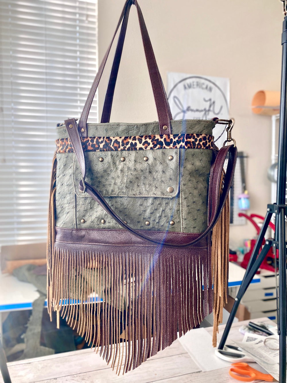 Rhonda's Custom Archive Mini in Moss Ostrich with Dark Roast cowskin leather accents, Leopard print cowskin top stripe accent, antique brass hardware, and lots of Dark Roast leather fringe on the sides and bottom
